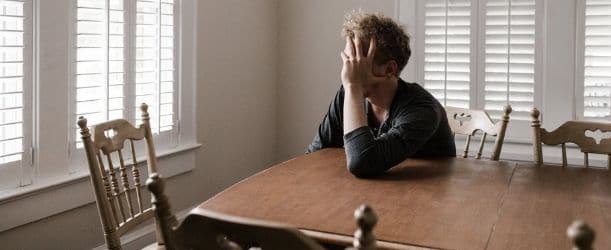 man sitting at table upset