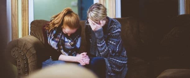 couple holding hands and upset