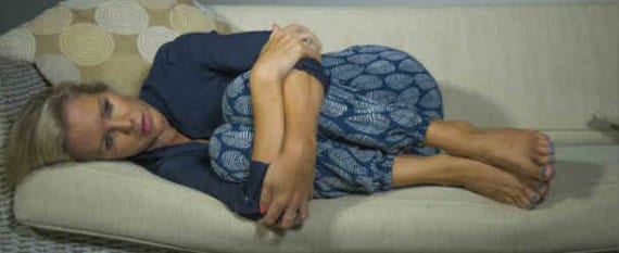 woman in fetal position on couch