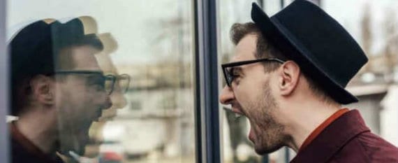Man screaming at his reflection