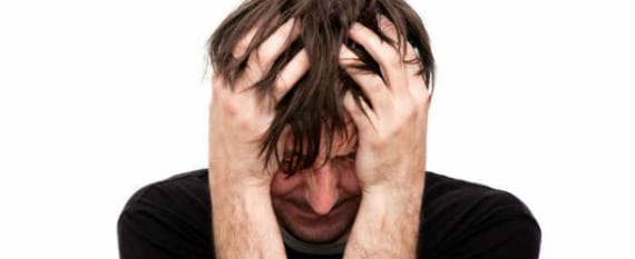 A man pulling at his hair and stressed out