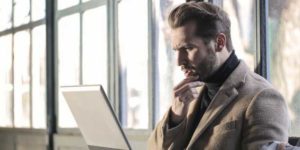 frustrated man working on a laptop