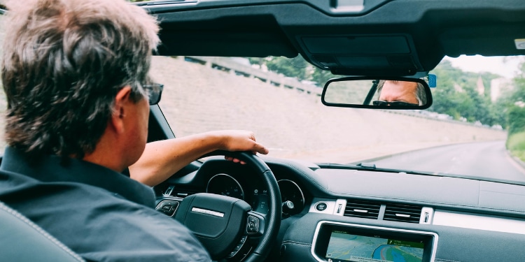 older man driving convertible car