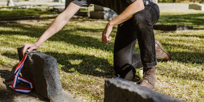 man grieving at cemetery