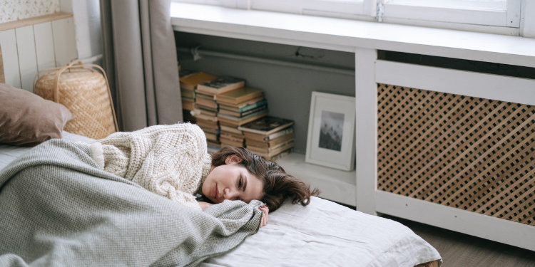 depressed woman laying in bed