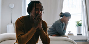 frustrated couple sitting on a bed