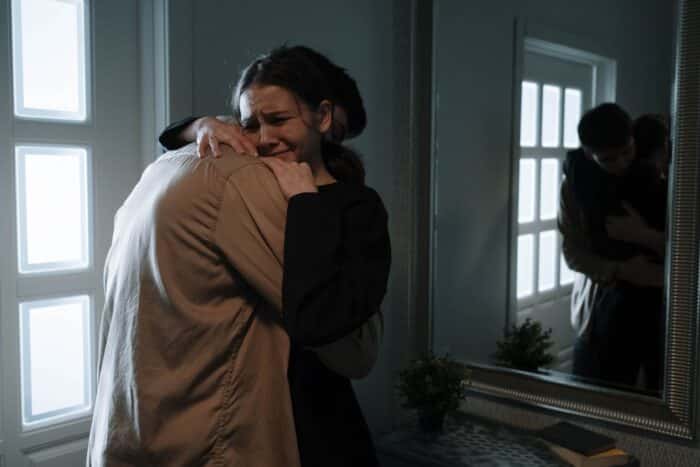 A girl crying while hugging a man