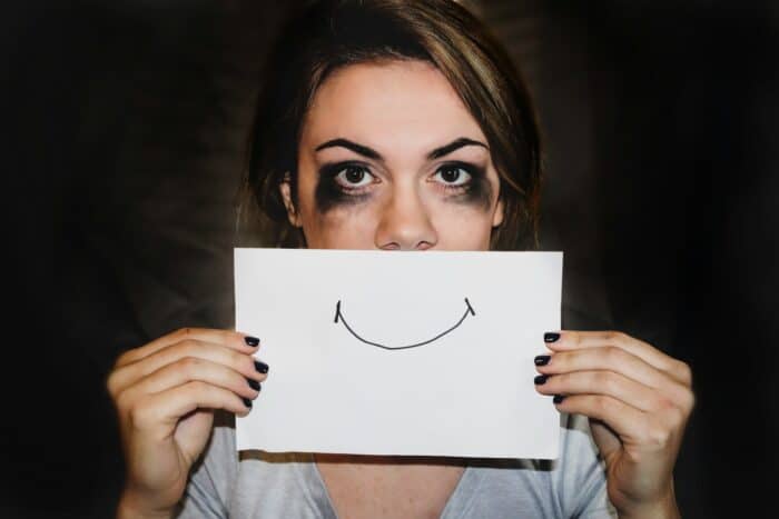 A person holding a drawing in front of their face.