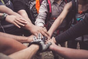 group of individuals join hands for teamwork