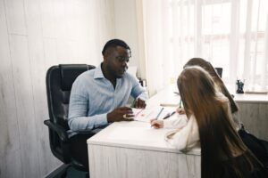 school counselor instructs two students at a desk