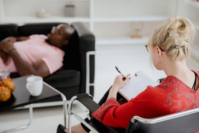 A professional therapist takes notes during a therapy session