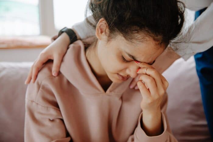A young woman experiences emotional support from a friend