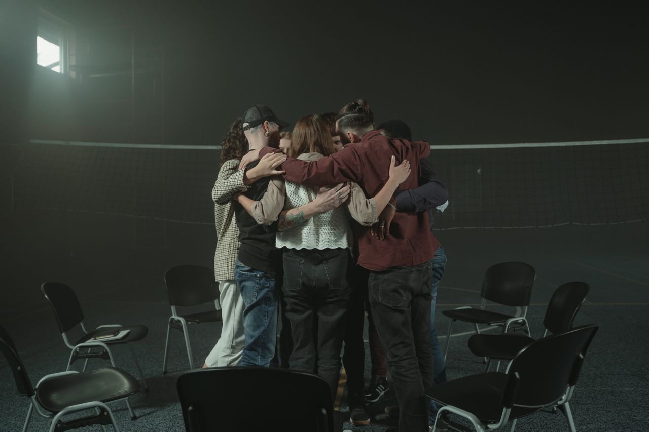 a group of people hugging after a group therapy session