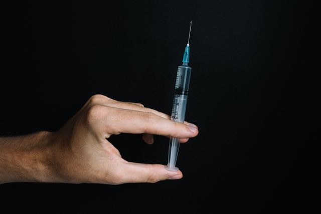 hand holding a syringe